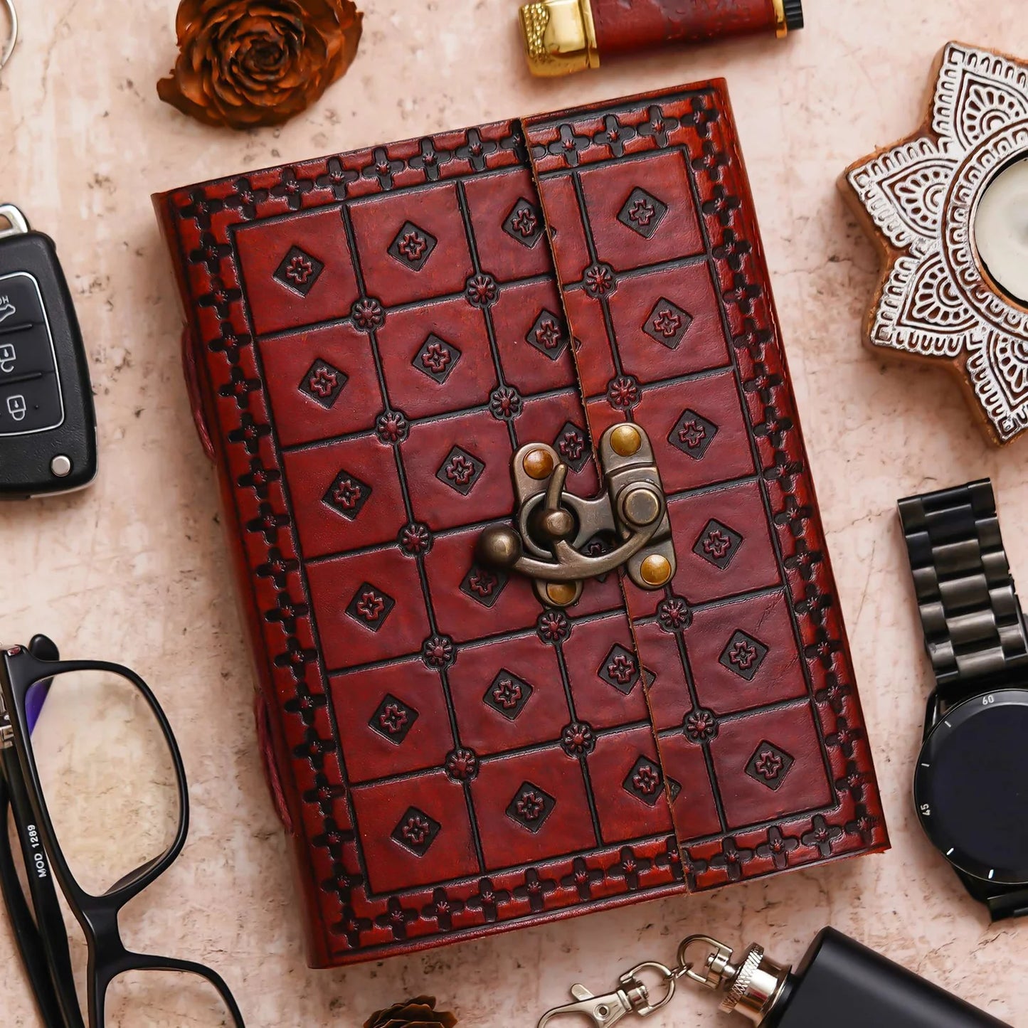 Open notebook on a textured surface with a pen, small plant, and decorative items.