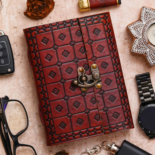 Open notebook on a textured surface with a pen, small plant, and decorative items.
