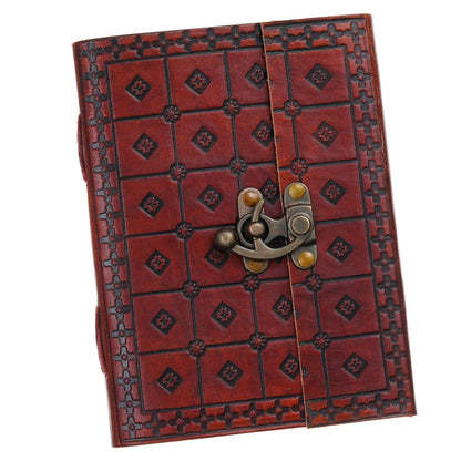 Open notebook on a textured surface with a pen, small plant, and decorative items.