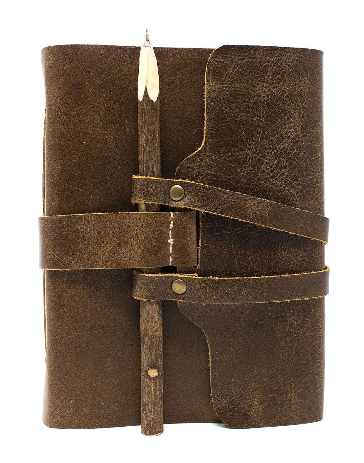 Brown leather journal with wooden pen holder on a white background