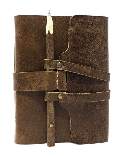 Brown leather journal with wooden pen holder on a white background