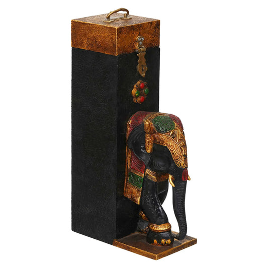 Decorative elephant figure with ornate details on a black stand against a white background