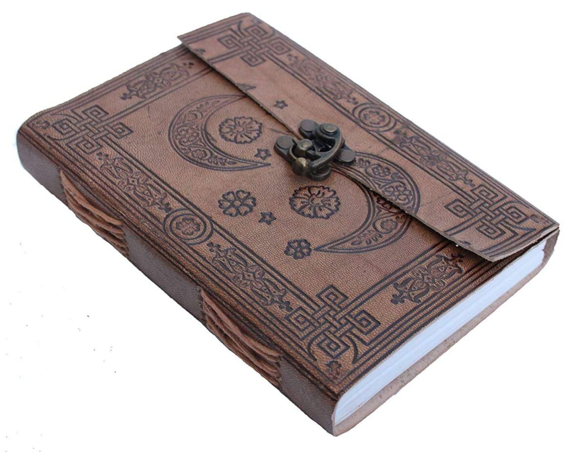 Brown leather notebook with embossed designs and a buckle on a white background